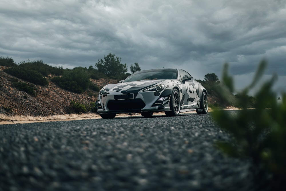 a white sports car parked on the side of the road