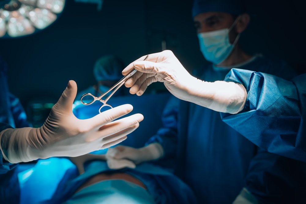 a person in a surgical gown is holding a pair of scissors