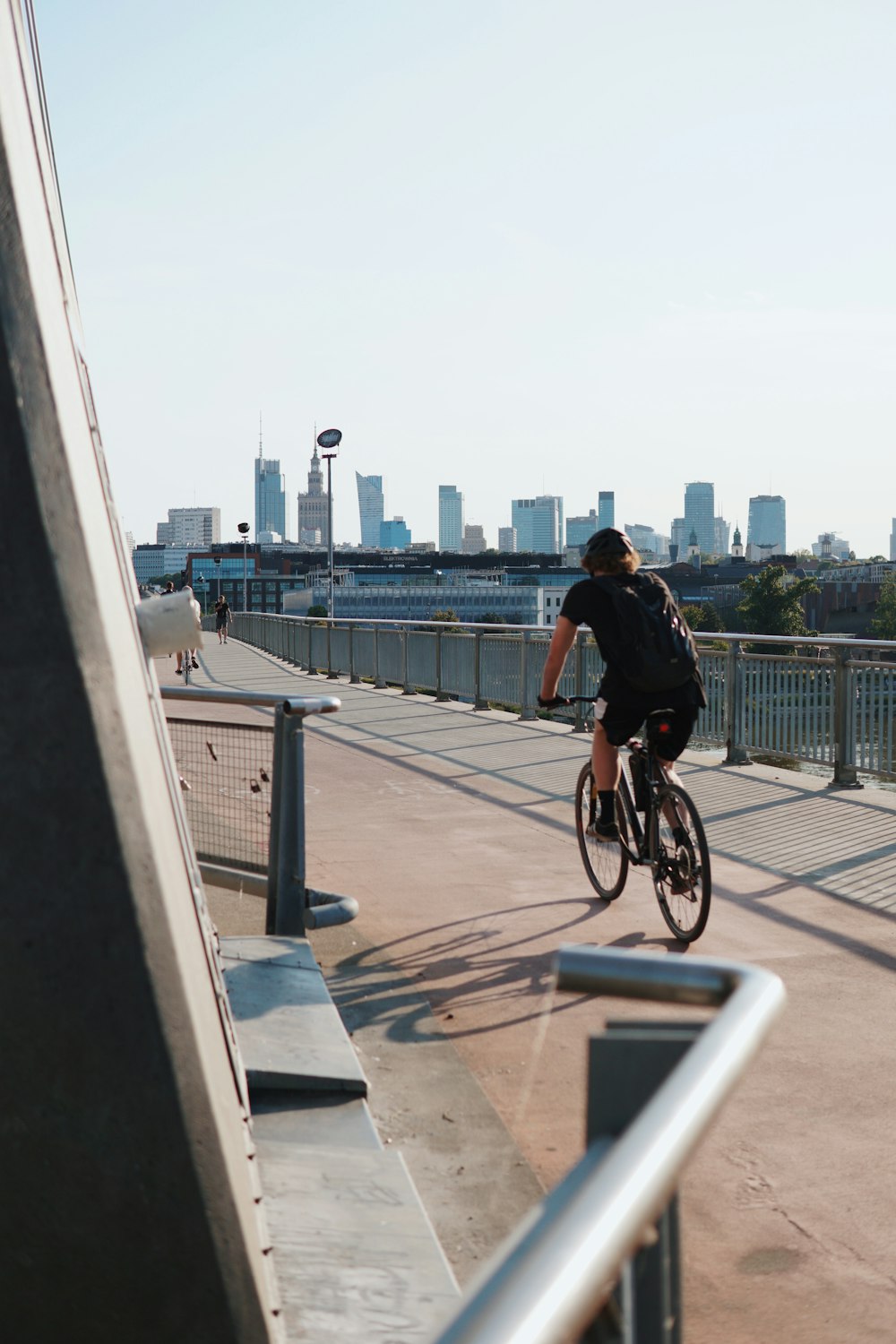 um homem andando de bicicleta por uma ponte