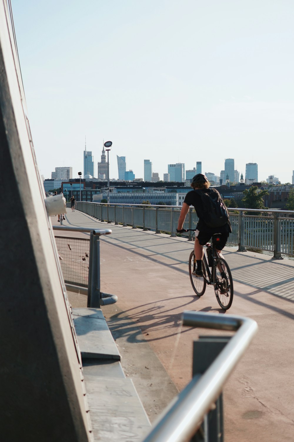 a man riding a bike across a bridge