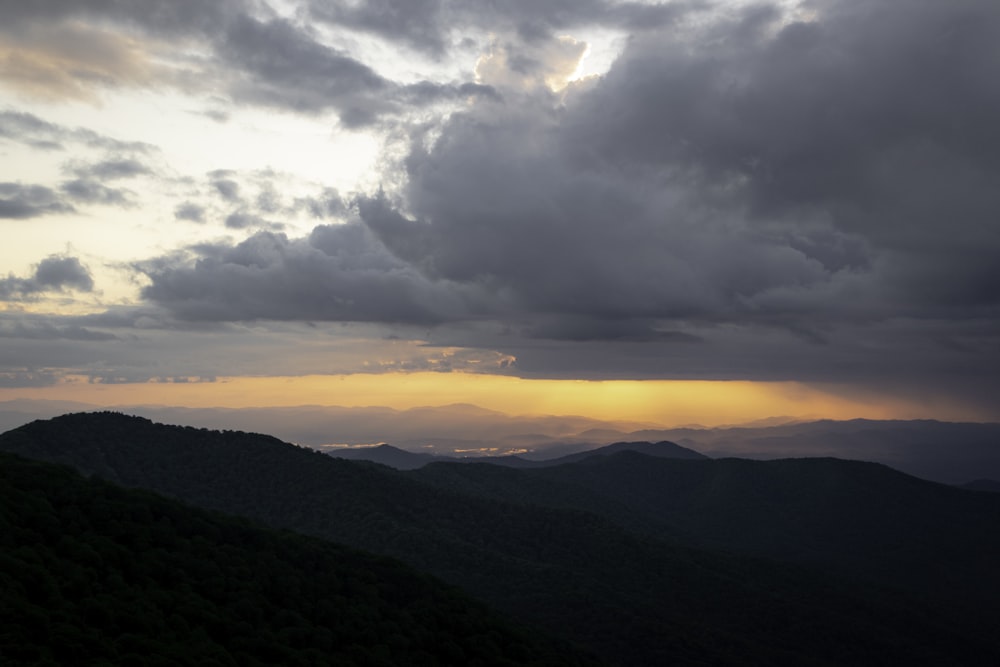 a view of a mountain range with clouds in the sky