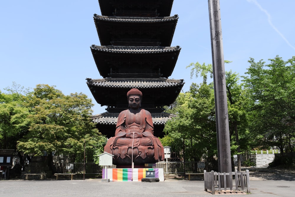 a large buddha statue sitting in front of a tall pagoda