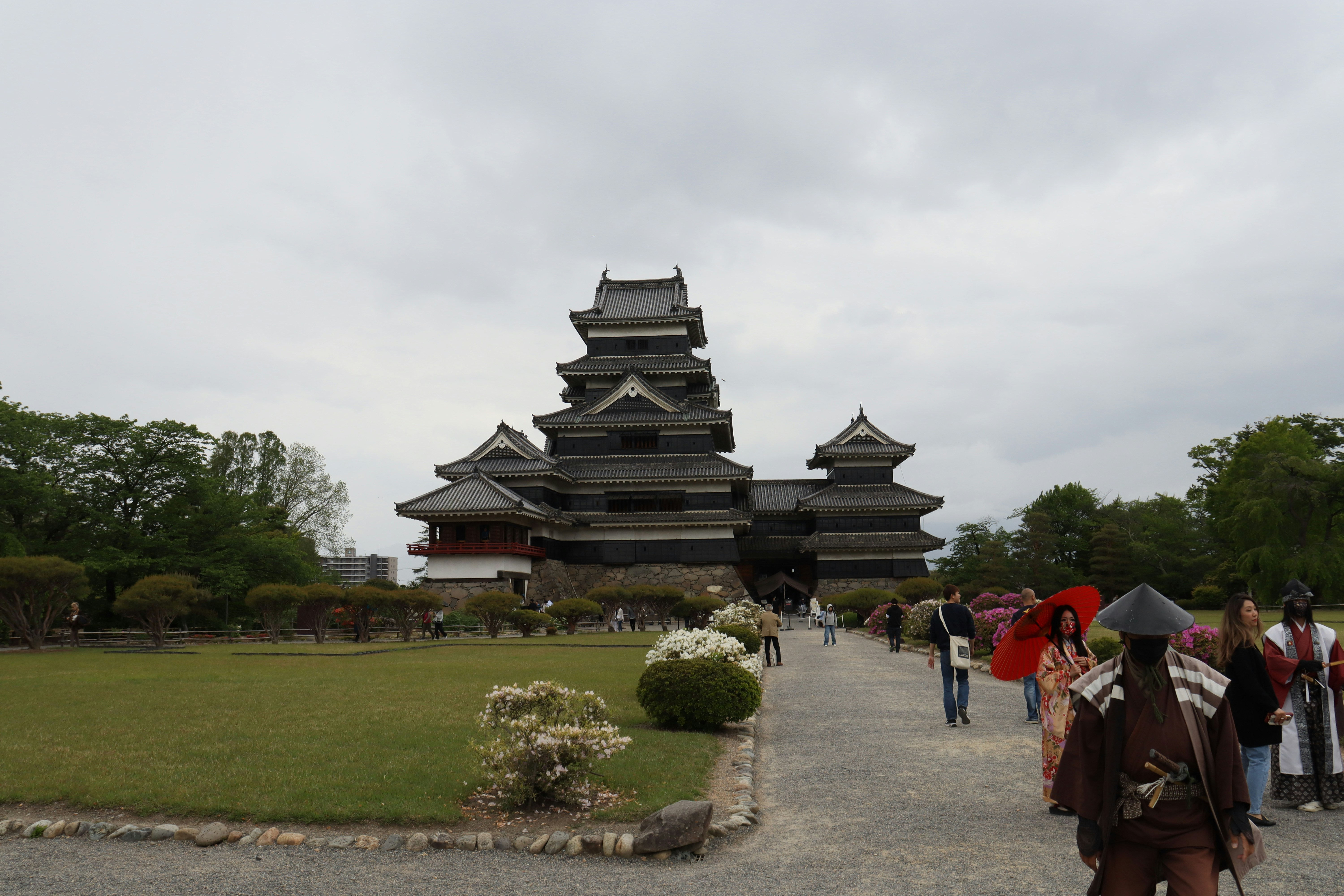 a group of people walking in front of a tall building, 