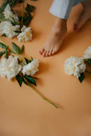 a person standing on a table with flowers on it