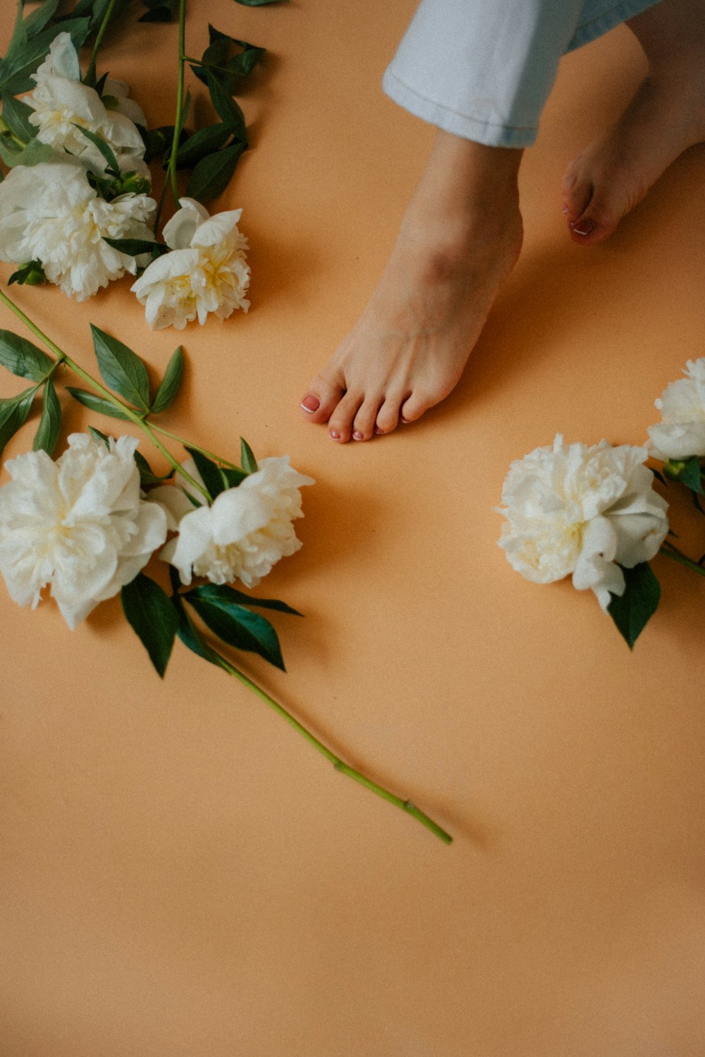 a person standing on a table with flowers on it