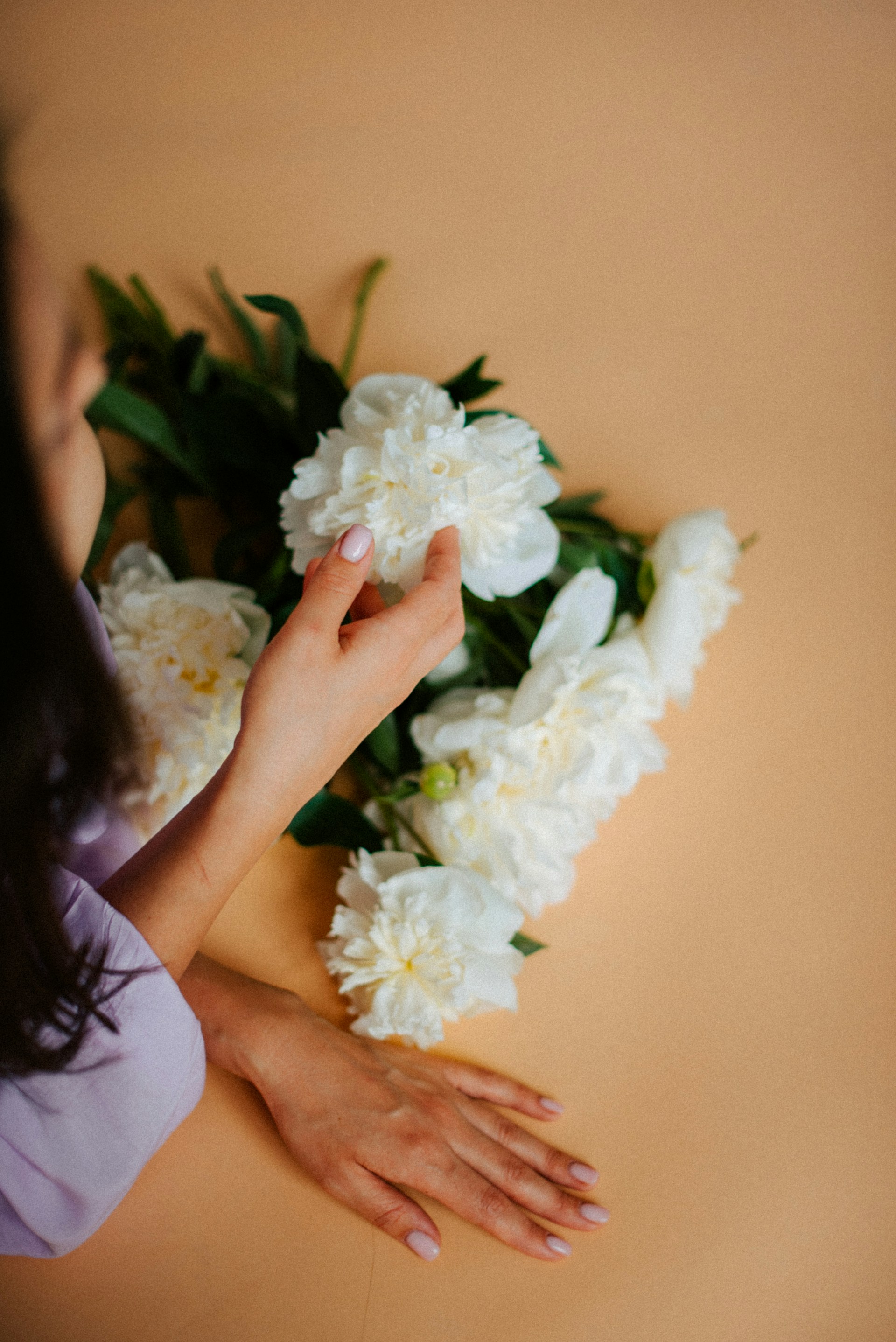 a woman holding a bunch of white flowers