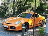 An orange sports car shining under bright sunlight, displayed with contact buttons for quick rental inquiries.