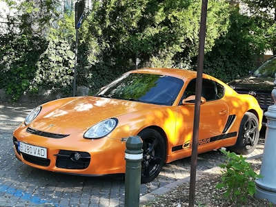 An orange sports car shining under bright sunlight, displayed with contact buttons for quick rental inquiries.