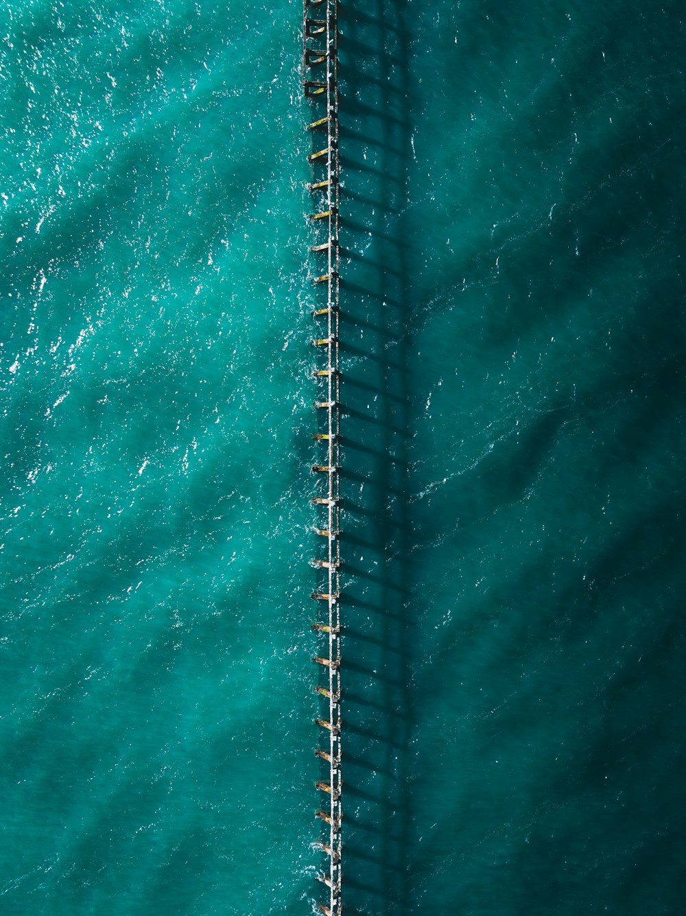 an aerial view of a dock in the ocean