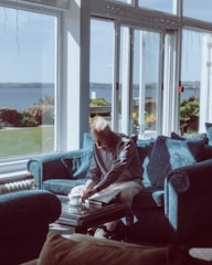 A relaxed homeowner smiling while reviewing documents in a cozy living room.