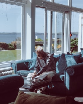 A relaxed homeowner smiling while reviewing documents in a cozy living room.