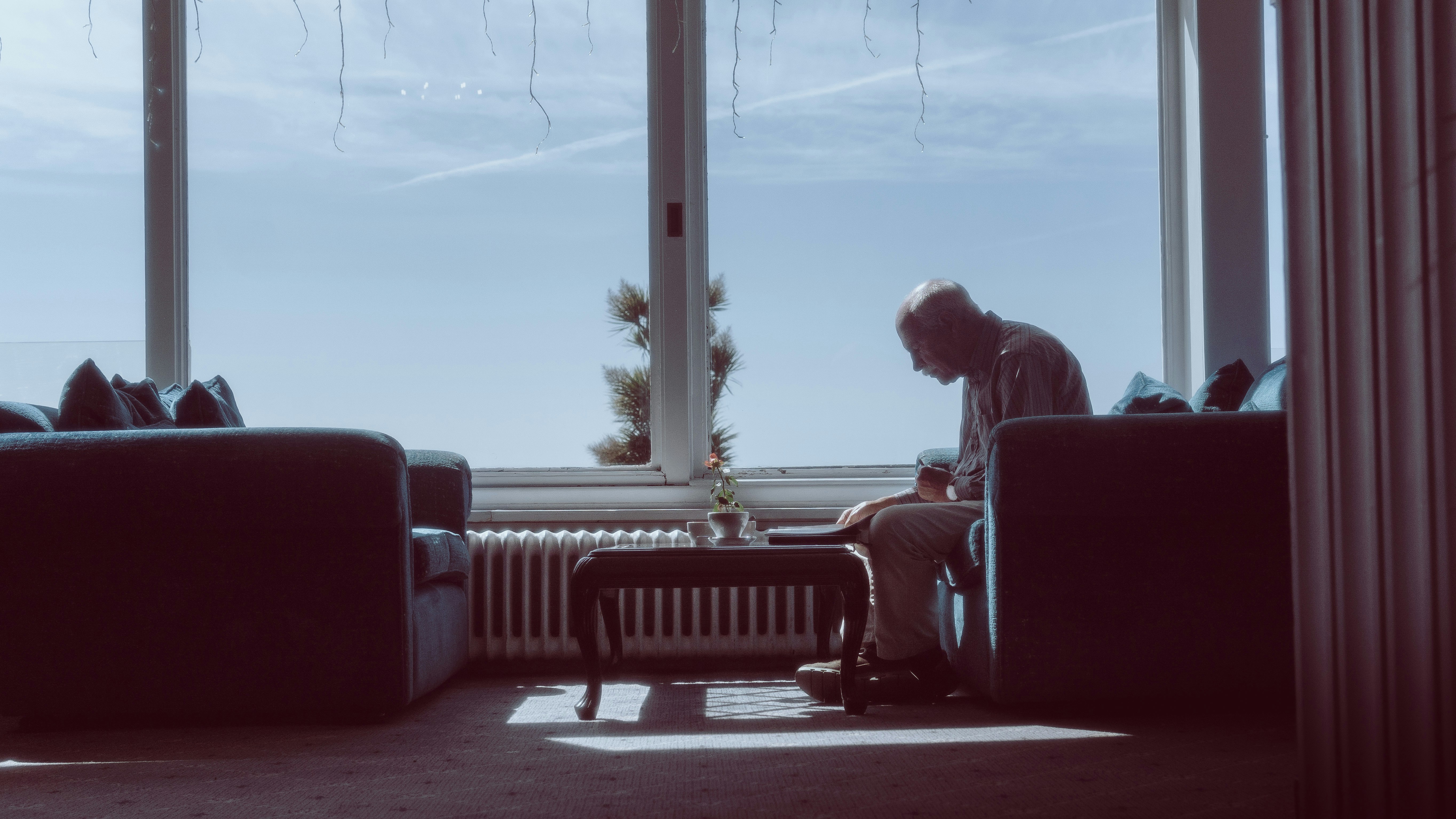 a man sitting on a couch in front of a window