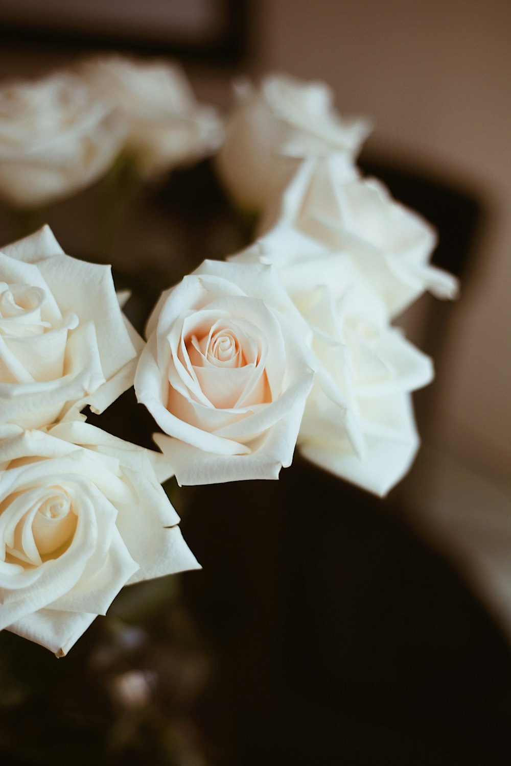 テーブルの上にある白いバラでいっぱいの花瓶