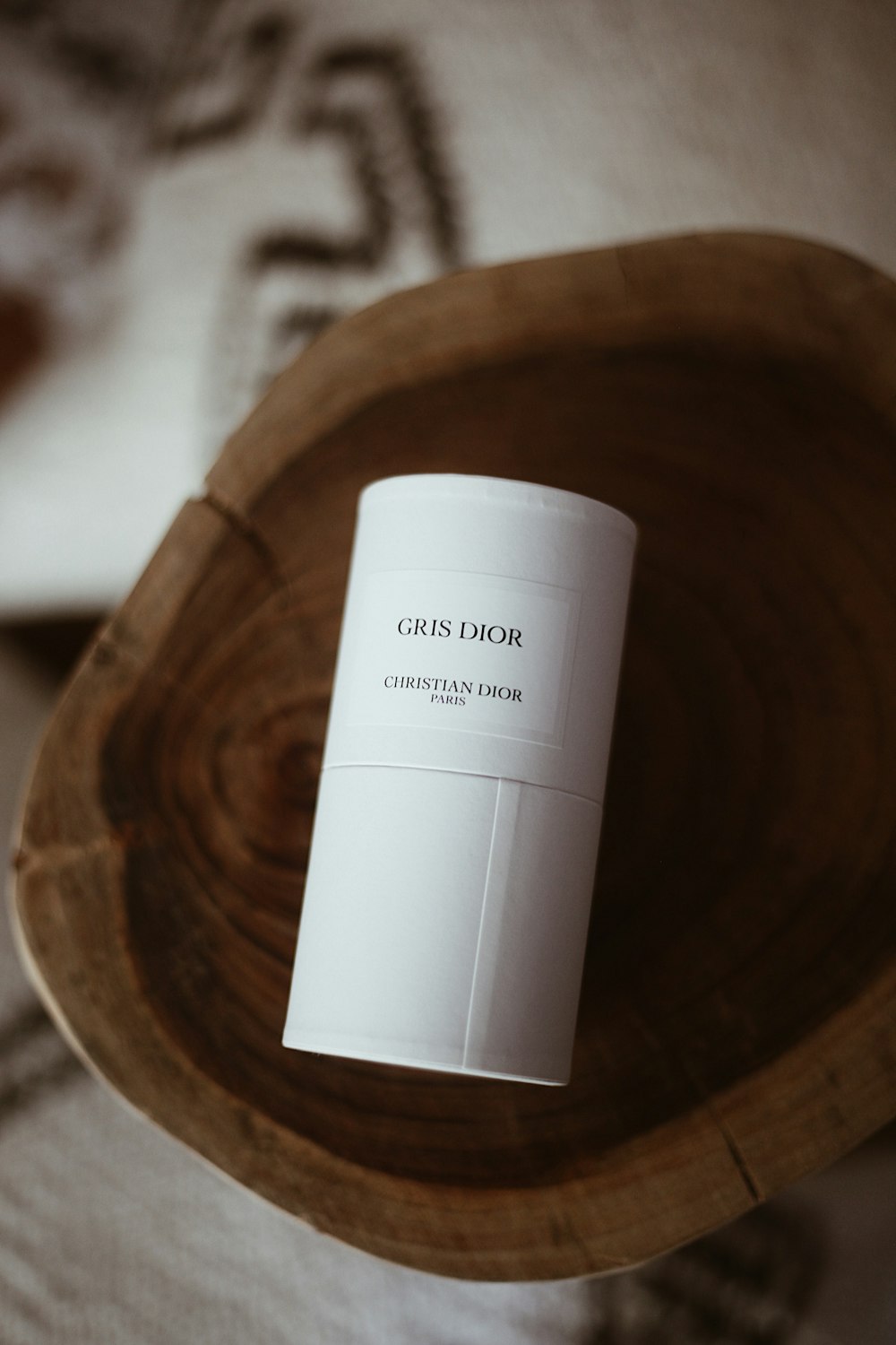 a white coffee cup sitting on top of a wooden bowl