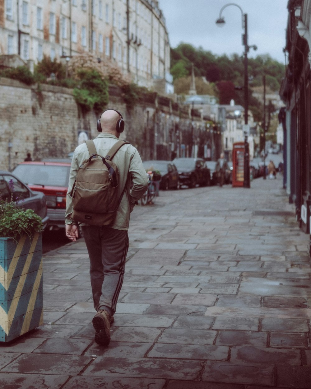 a man with a backpack walking down a street