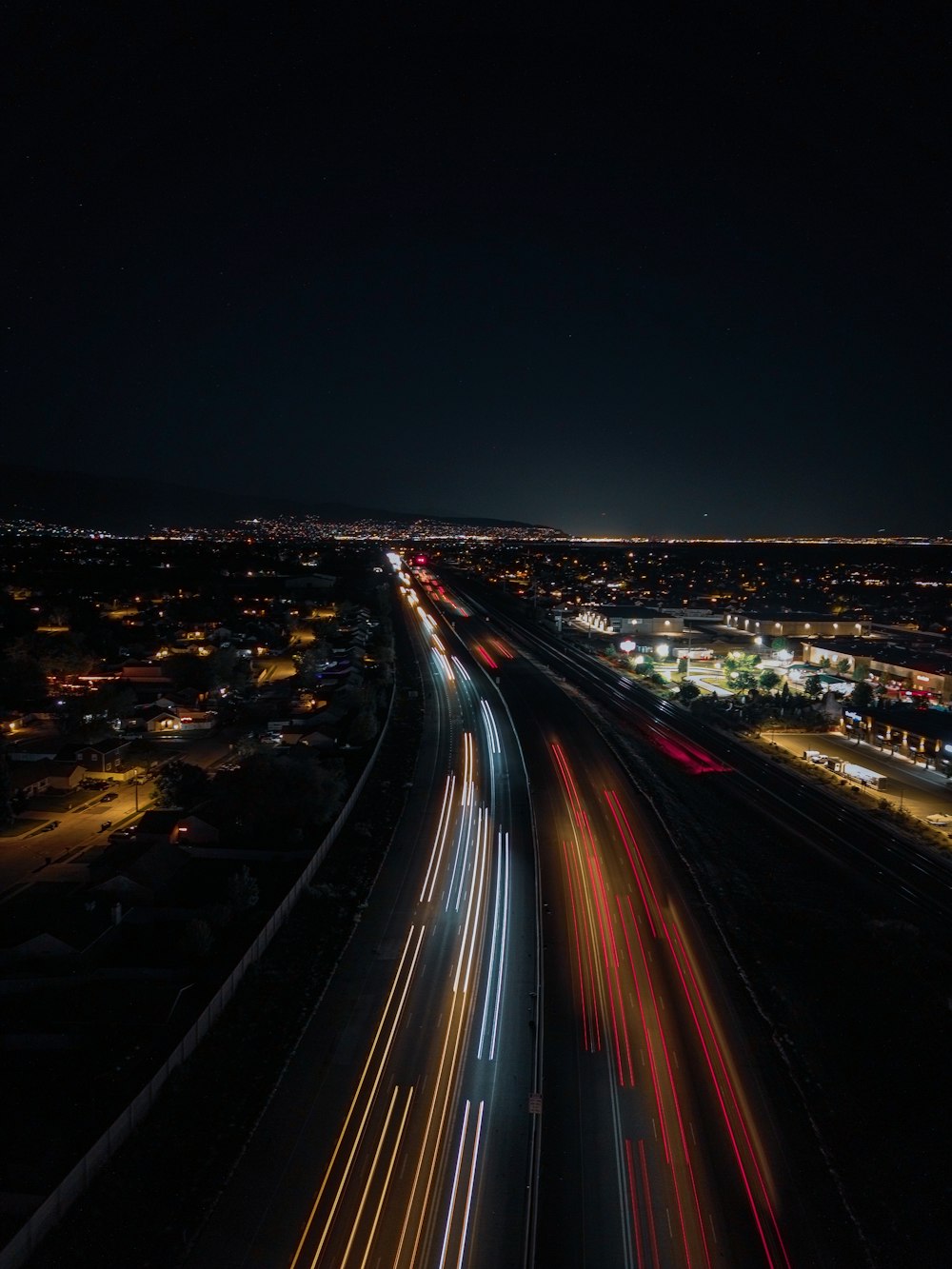 a night time view of a highway with a city in the background