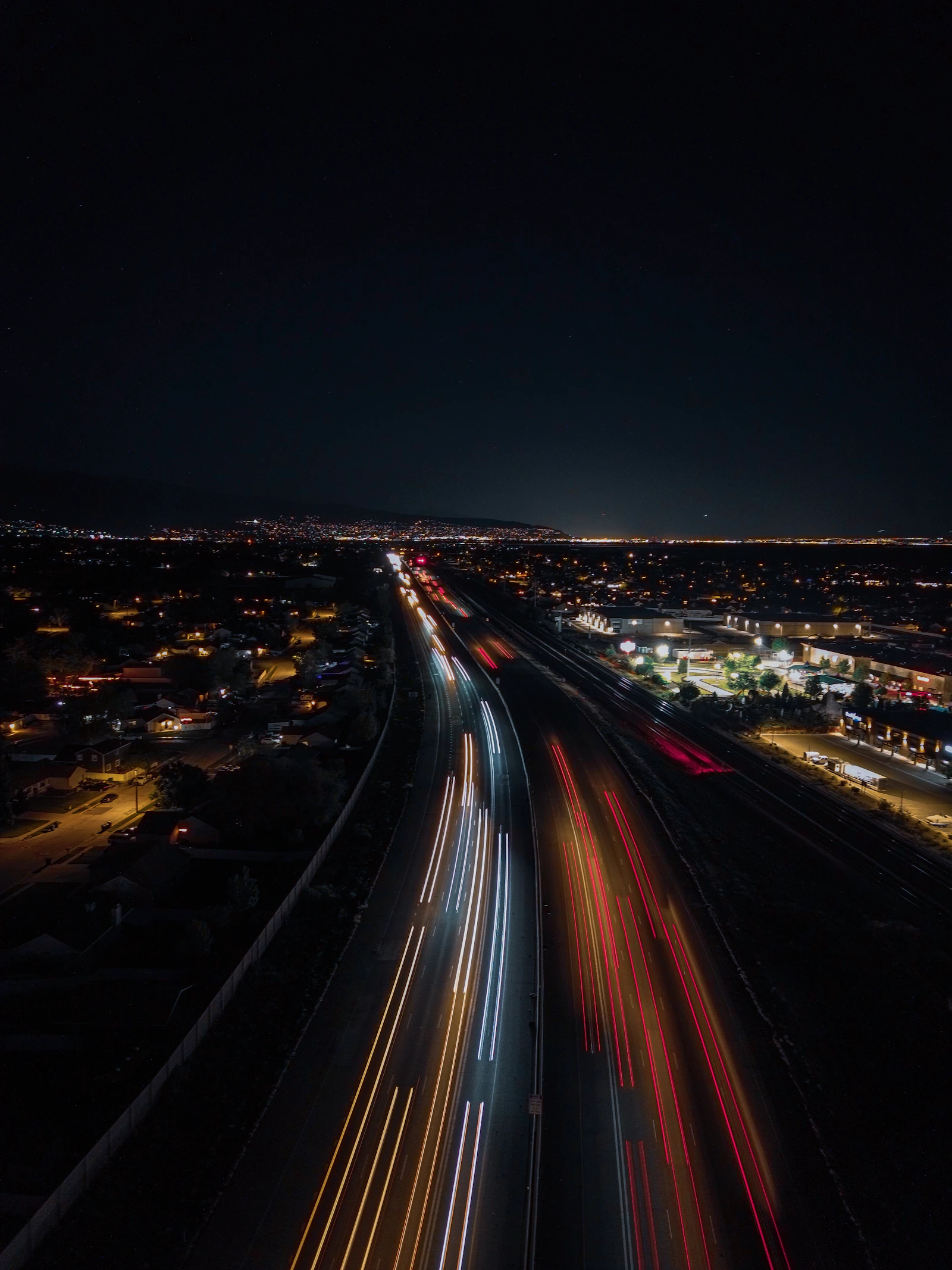 A night time view of a highway with a city in the background