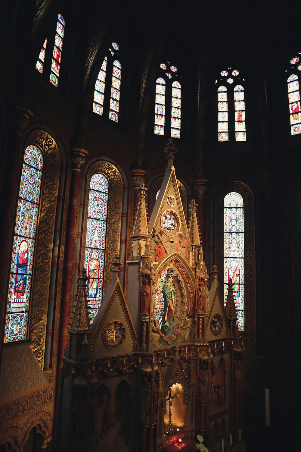 eine Kirche mit Buntglasfenstern und einem goldenen Altar