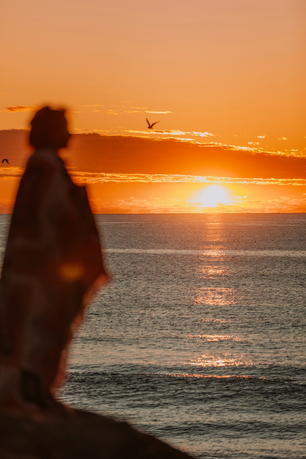 Un uomo in piedi sulla cima di una spiaggia vicino all'oceano