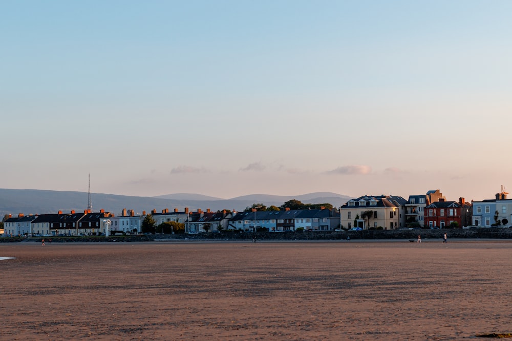 a group of houses sitting on top of a sandy beach