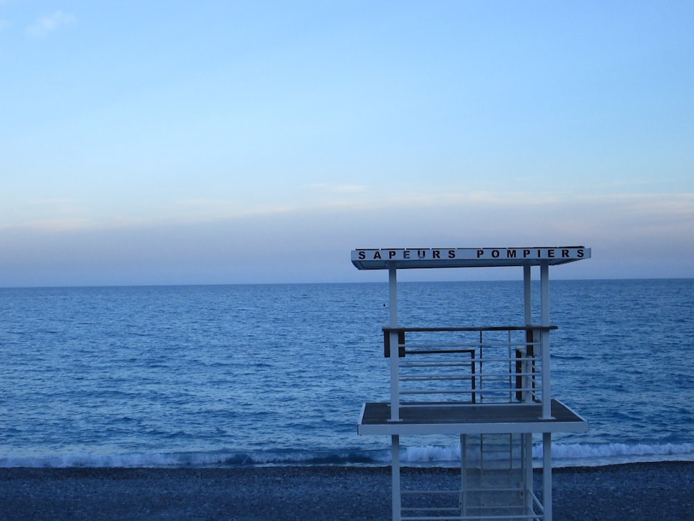 a lifeguard stand on the beach with the ocean in the background