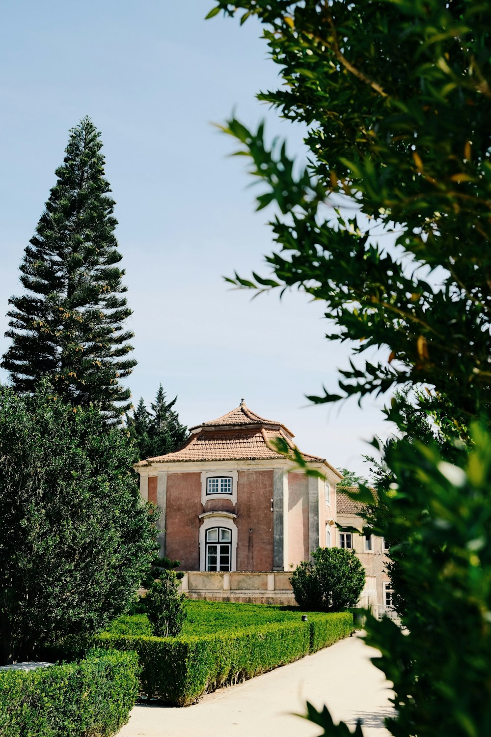 a large house surrounded by hedges and trees