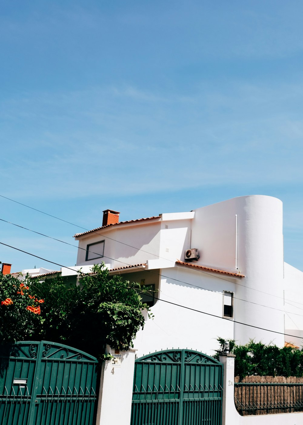 Un edificio blanco con una puerta verde y una torre del reloj