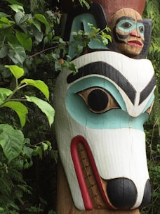 a wooden statue of a dog with a human face on it's head