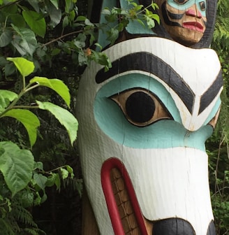 a wooden statue of a dog with a human face on it's head