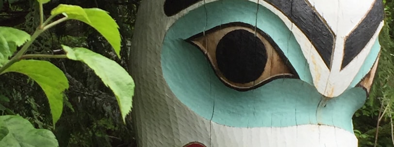 a wooden statue of a dog with a human face on it's head