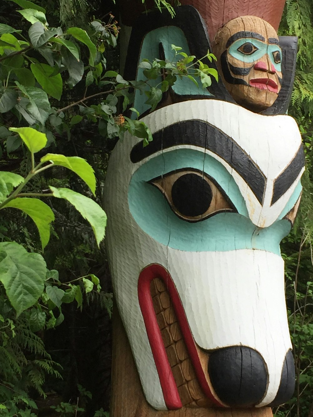 a wooden statue of a dog with a human face on it's head