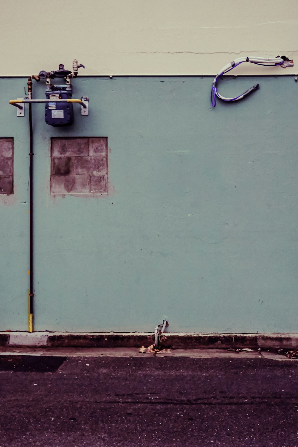 a blue wall with pipes attached to it