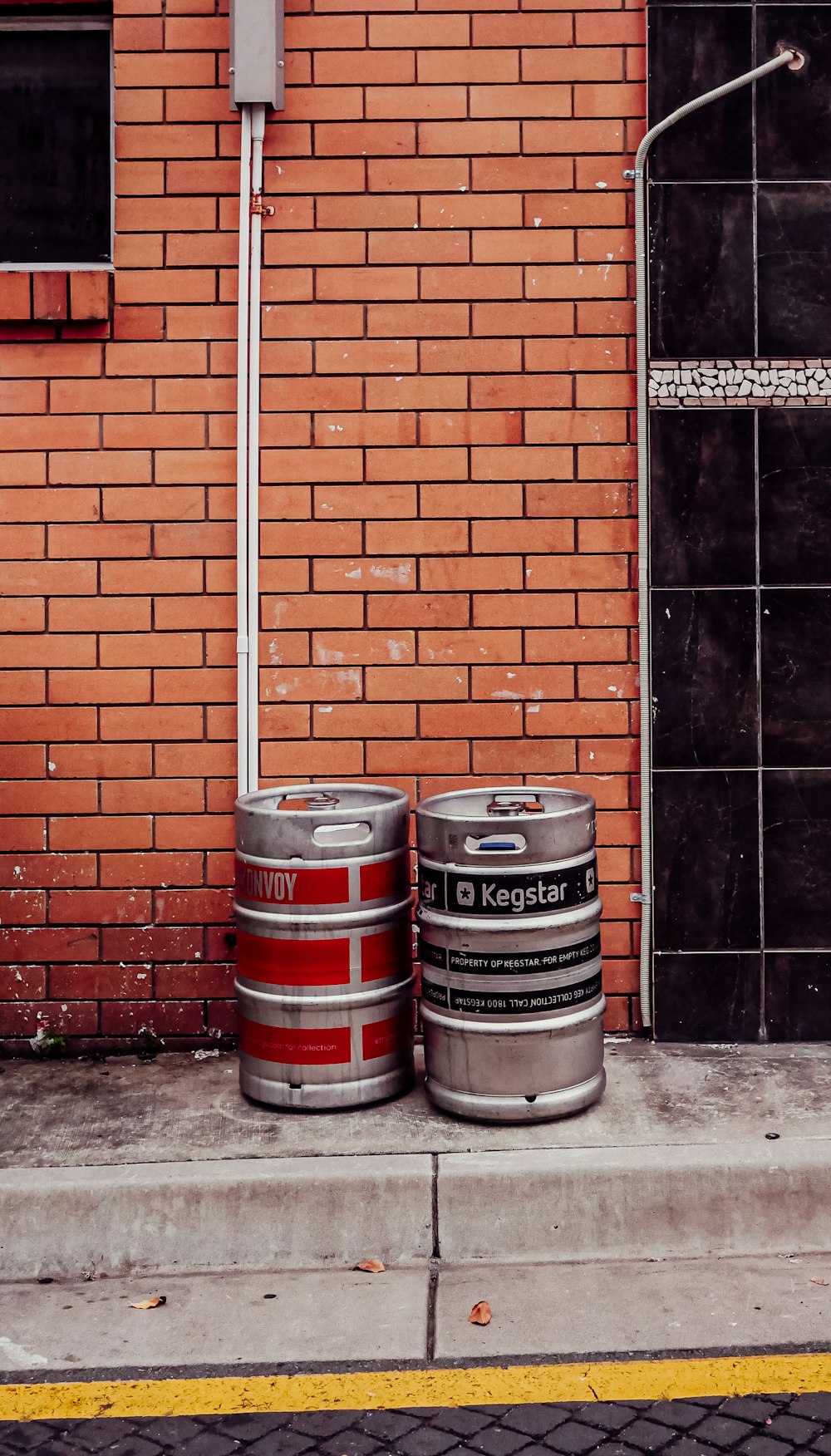 two kegs sitting next to each other on a sidewalk