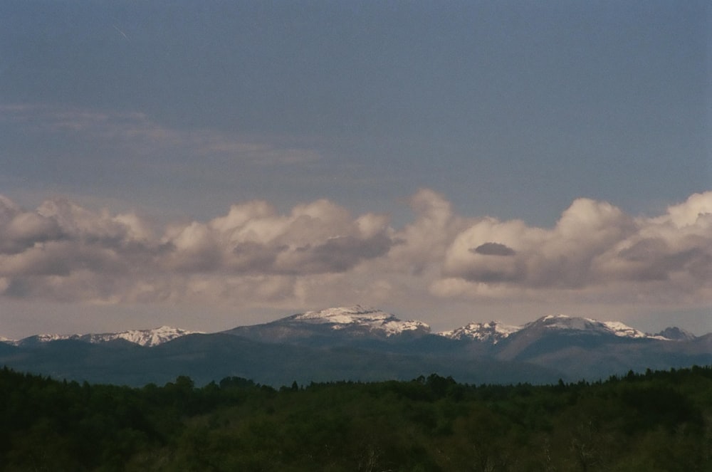 a mountain range with snow capped mountains in the distance