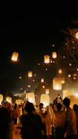 Close-up of vibrant colored smoke and sky lanterns drifting upwards during a festive university event.