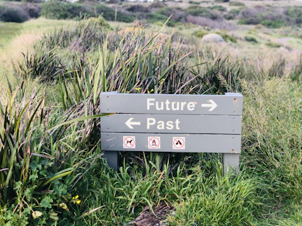 a sign in the middle of a grassy field