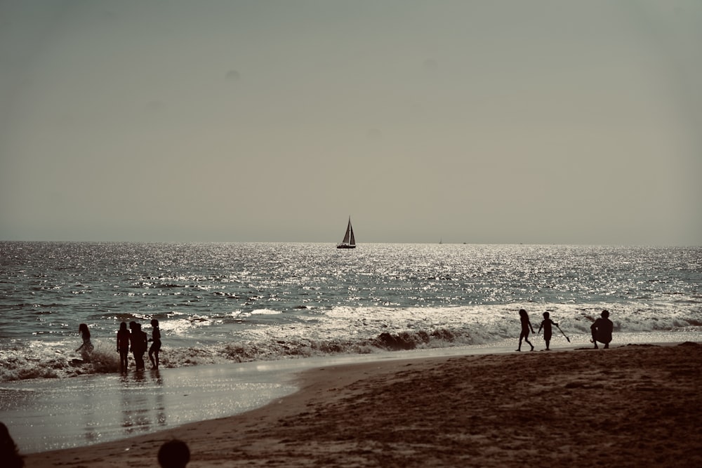 a group of people standing on top of a sandy beach