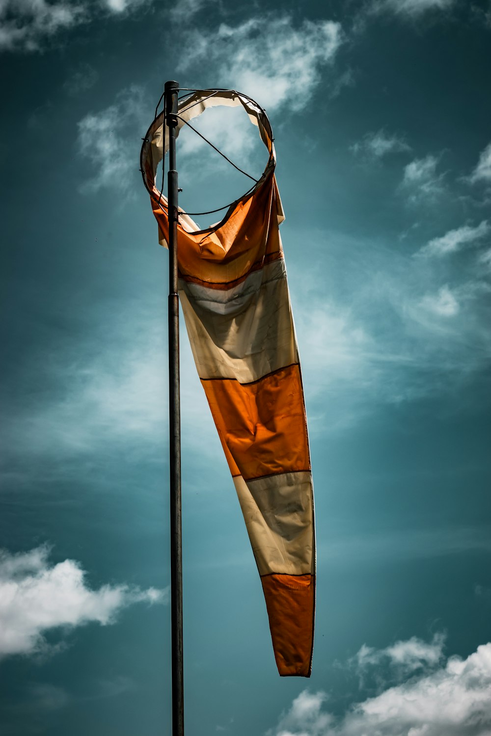 a large orange and white flag on top of a pole