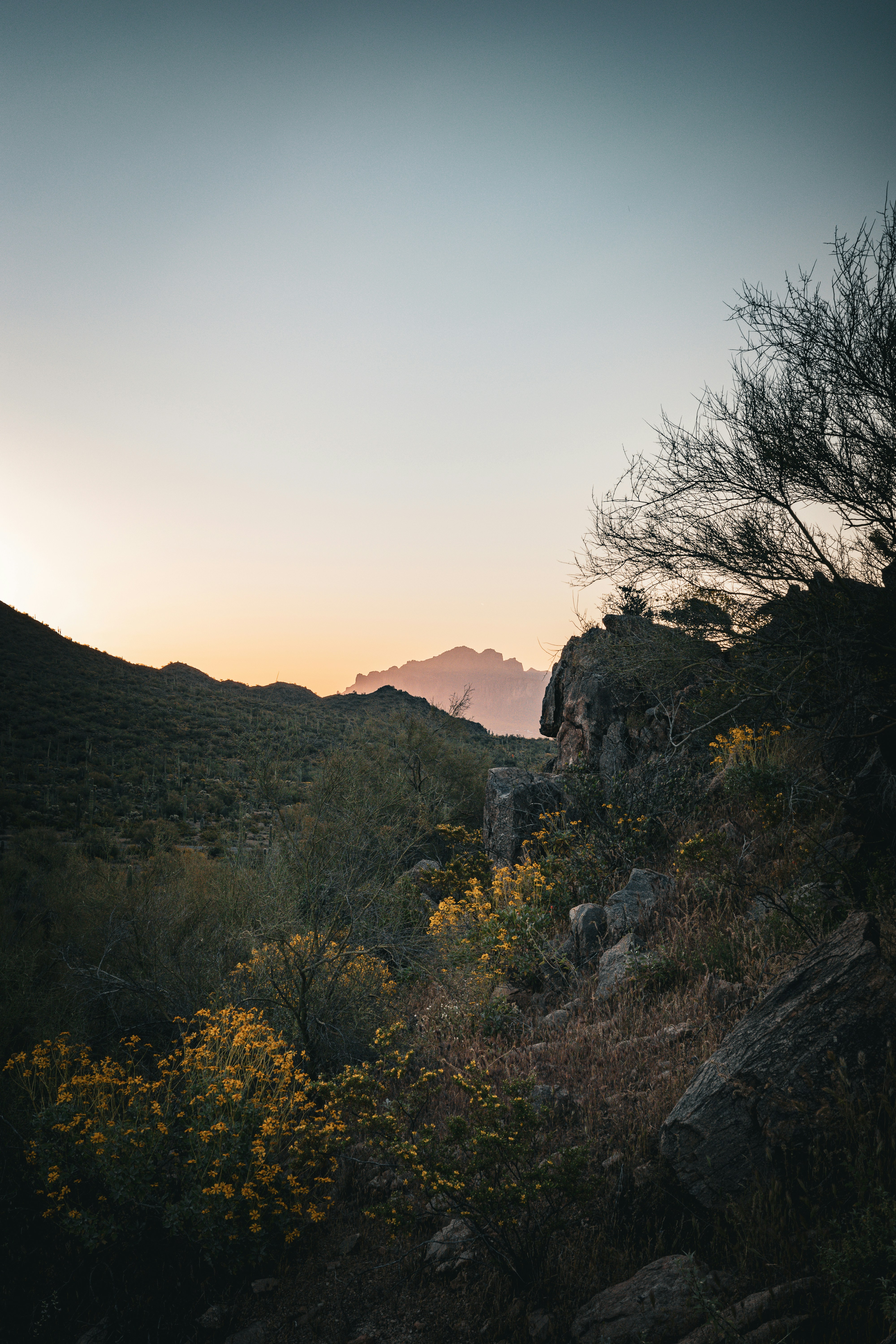 the sun is setting over the mountains in the distance