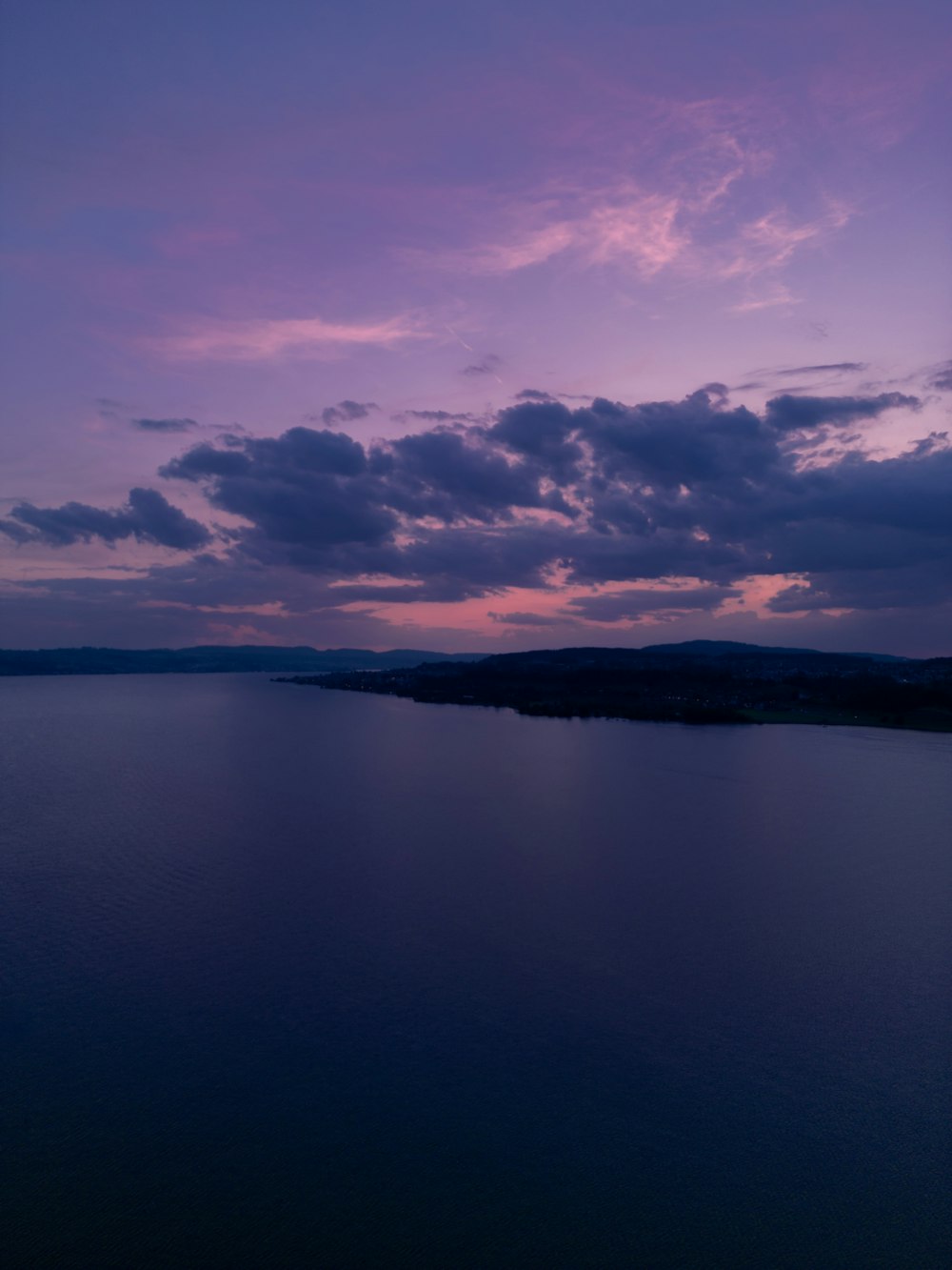 a large body of water under a purple sky