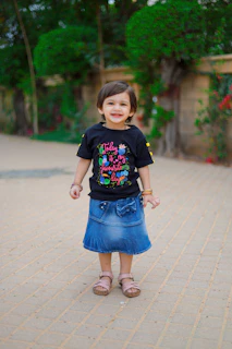 A child proudly wearing their first new shoes, standing on a city sidewalk.