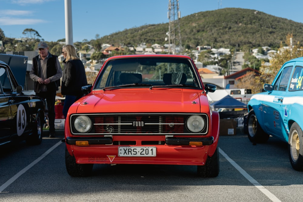 a red car parked in a parking lot next to other cars