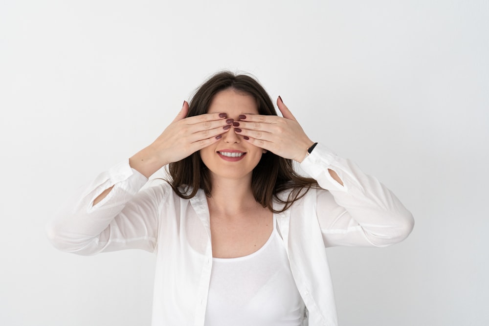 a woman covering her eyes with her hands