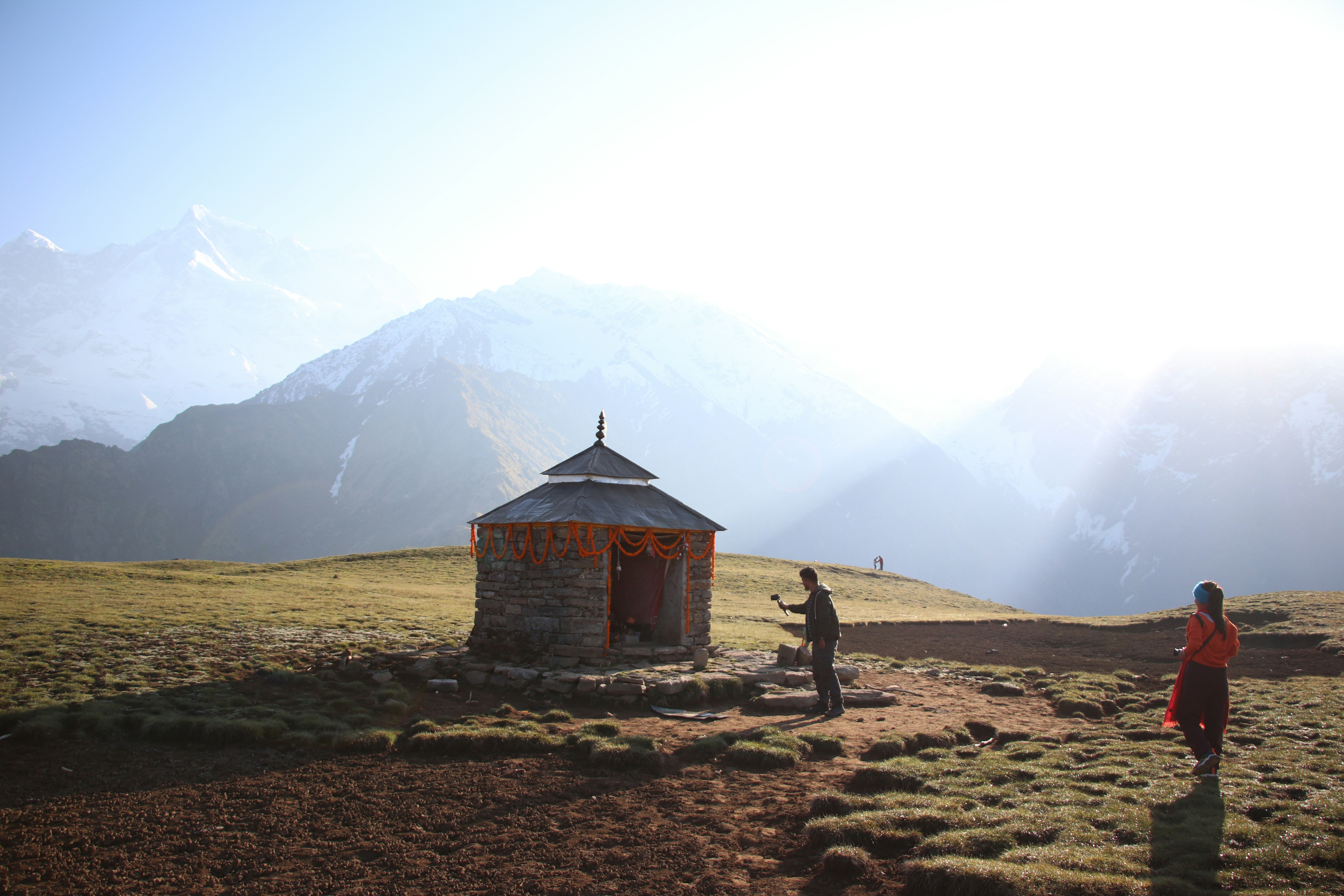 a couple of people standing on top of a grass covered field