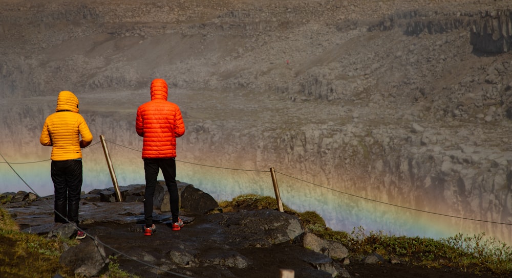 a couple of people standing on top of a hill