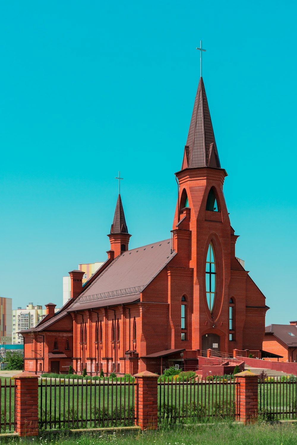 a church with a tall steeple and a fence