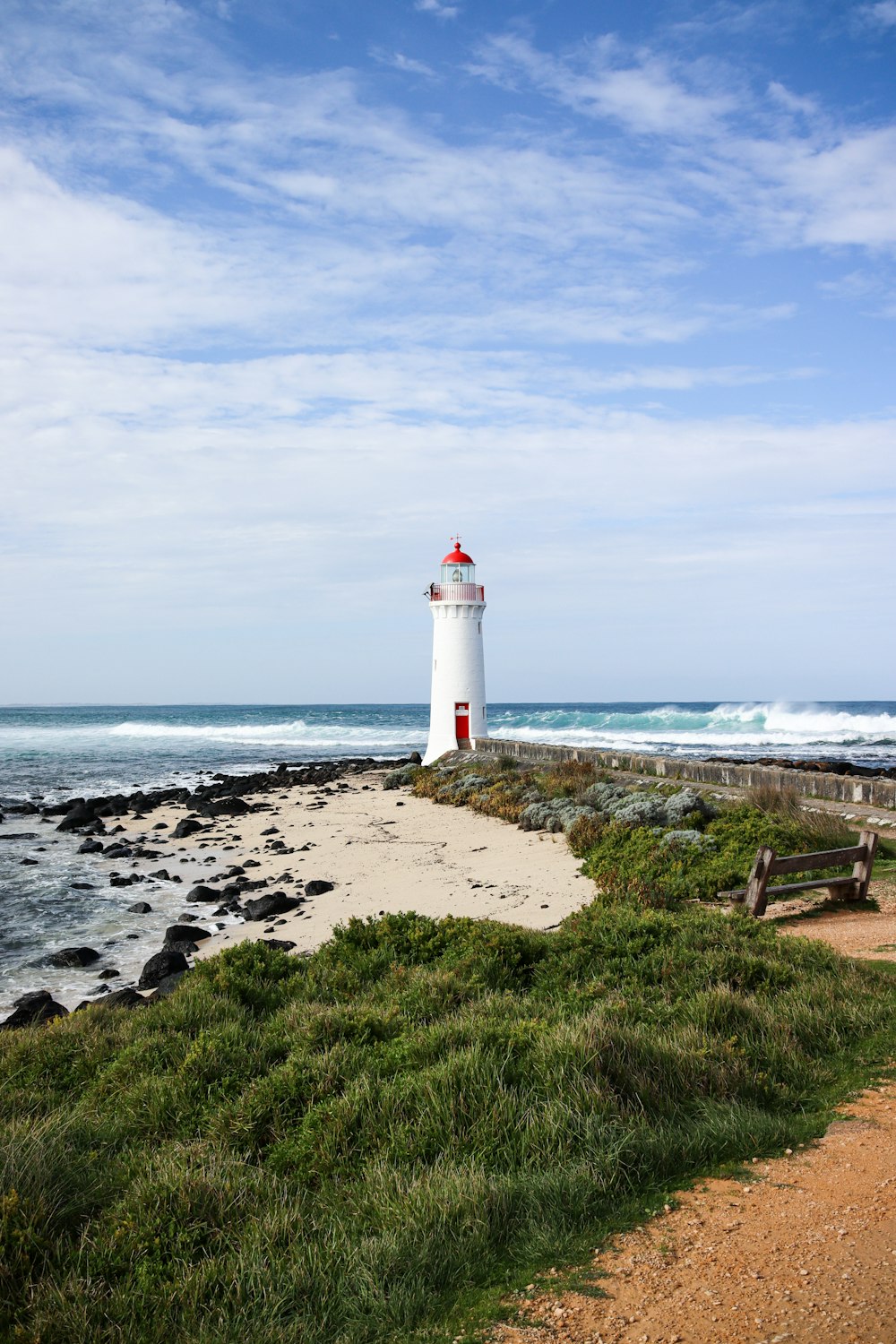 a light house sitting on top of a sandy beach