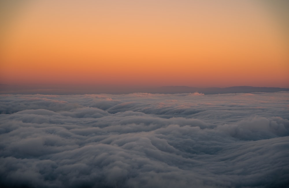 the sun is setting over the clouds in the sky