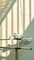 A pair of tri-star sneakers resting on a wooden bench with sunlight filtering through leaves