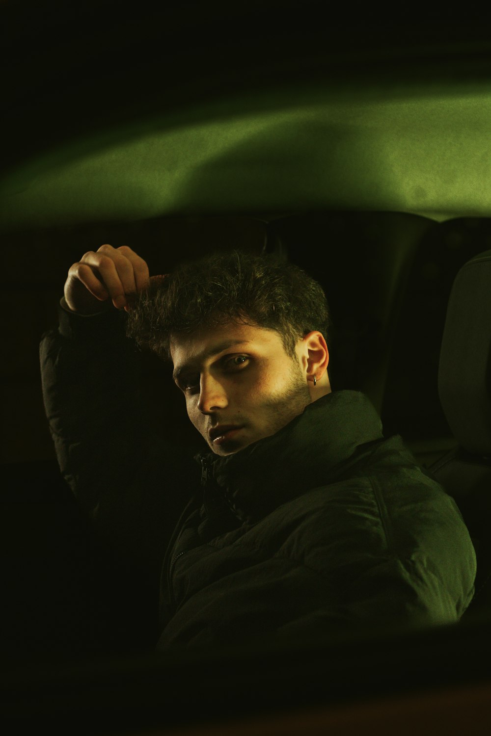 a man sitting in a car in the dark